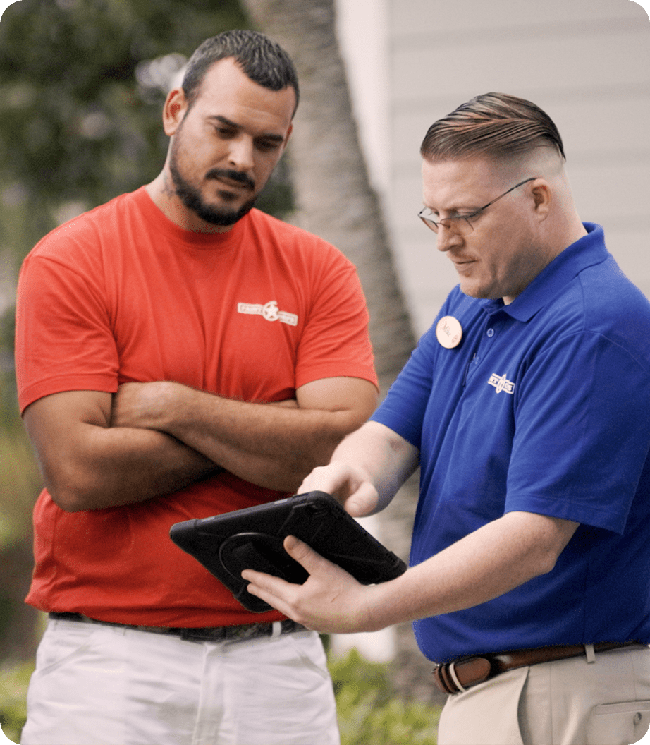 two paint corps contractors looking over tablet