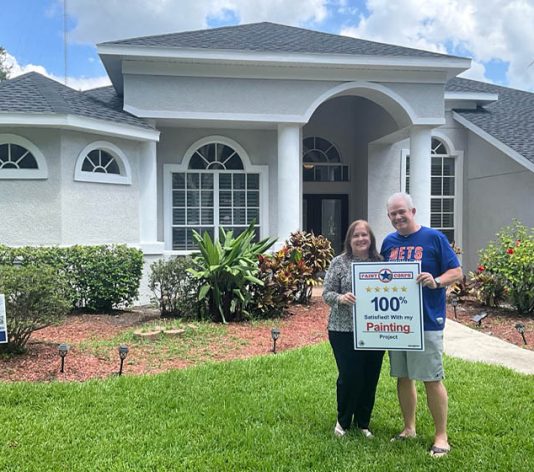 homeowners smiling for portrait in font of house