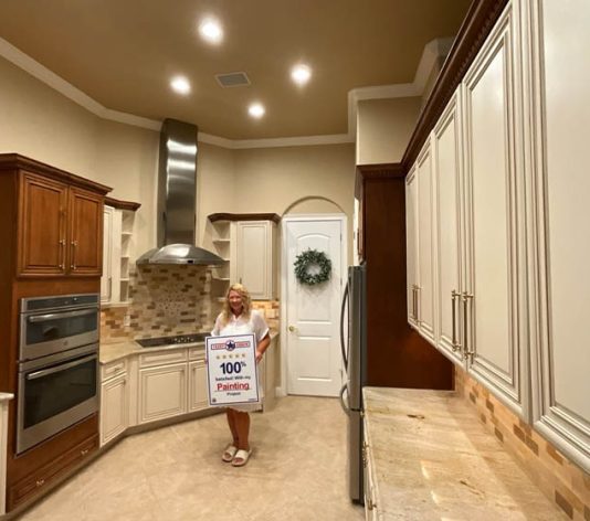 homeowner smiling inside her newly painted kitchen